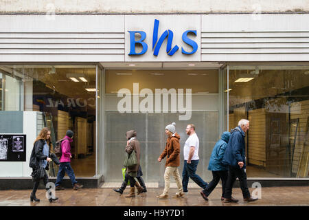 Exeter, England, UK - 22 November 2016: Unidentified people walk by permanently closed BHS shop on Fore Street. Stock Photo