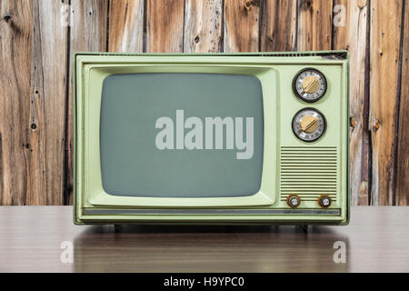Grungy green vintage television set with old wood paneling. Stock Photo