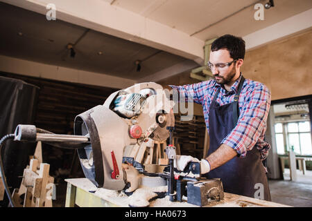 Carpenter Using Circular Saw for wood at his workshop Stock Photo