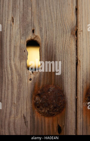 Hole in a wooden door to look Stock Photo