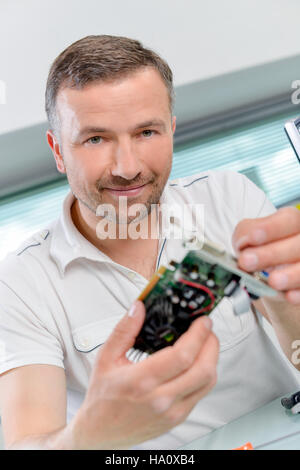 PC repair man holding a graphics card Stock Photo