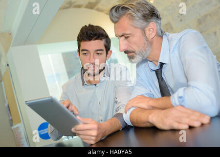 business executive and co-worker using digital tablet in office Stock Photo