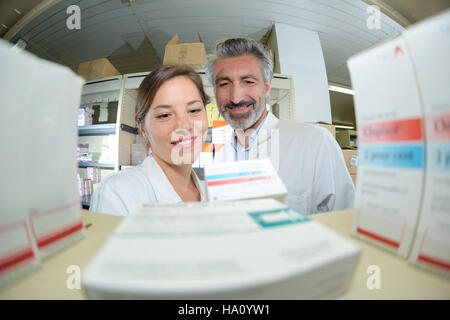 pharmacists checking medicines on shelf in pharmacy Stock Photo