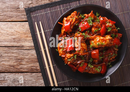 Pork braised in sweet and sour sauce with vegetables close-up in an Asian style. horizontal view from above Stock Photo