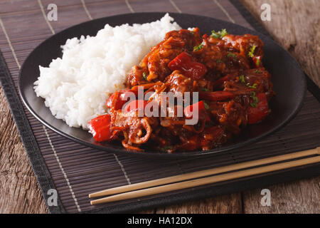 Pork braised in sweet and sour sauce with vegetables and rice close-up in an Asian style. horizontal Stock Photo