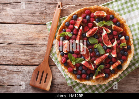 Freshly baked cake with fresh figs, raspberries and blueberries on the table. Horizontal view from above Stock Photo