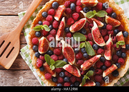 tart with fresh figs, raspberries and blueberries on the table. Horizontal view from above Stock Photo
