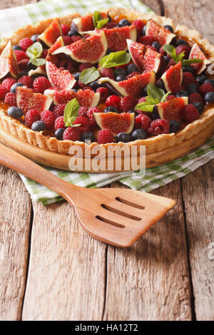Summer cake with fresh figs, raspberries and blueberries close-up on the table. Vertical Stock Photo