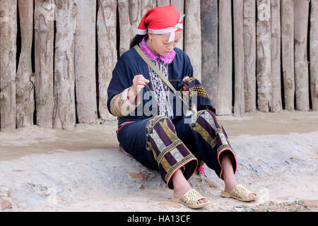 ethnic Red Dzao woman sewing on the street of Ta Phin, Lao Cai in Sapa, Vietnam, Asia Stock Photo