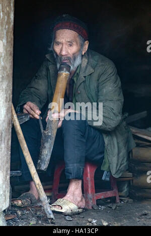 ethnic Vietnamese old man smoking his pipe in Ta Phin, Lao Cai in Sapa, Vietnam, Asia Stock Photo