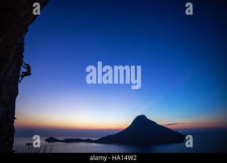 Rock climber on overhanging cliff at sunset. Kalymnos Island, Greece. Stock Photo