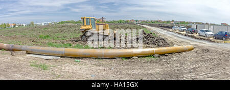 Panorama is showing with heavy earth mover construction machine, bulldozer at building site Stock Photo