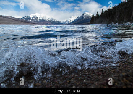 This image captures the powerful natural force of crashing waves on Lake McDonald, located in Glacier National Park, emphasizing the park's dynamic natural environment. Stock Photo