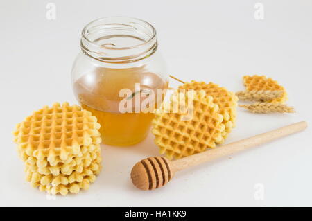 Bunch of golden baked waffle cookies and honey Stock Photo