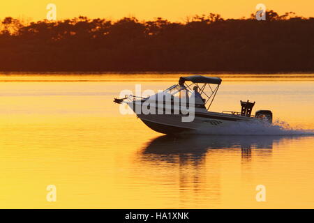 Dawn greets a couple on a boat - Pumicestone Passage off Golden Beach, Caloundra on the Sunshine Coast of Queensland, Australia. Stock Photo