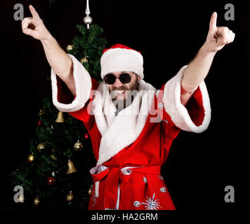 bad rastoman Santa Claus smiles and fun dancing on the background of Christmas tree Stock Photo