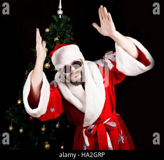 bad rastoman Santa Claus smiles and fun dancing on the background of Christmas tree Stock Photo