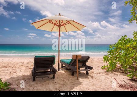 Tropical sandy beach with umbrella and beach chairs Stock Photo