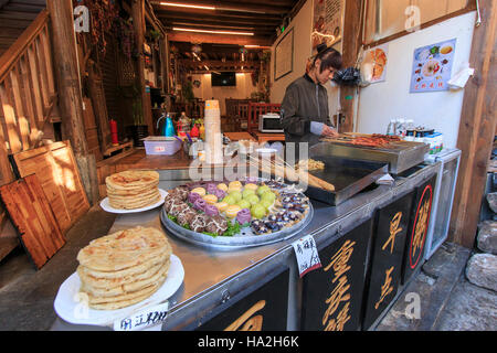 Lijiang, China - November 10, 2016: Woman preparing some traditional Chinese snaks in Lijiang Old Town Stock Photo