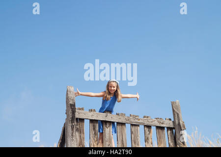 Girl standing on a fence Stock Photo