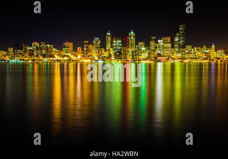 The Seattle skyline at night as seen from Alki. A long exposure lets Puget Sound soak up the colors of the city at night. Stock Photo