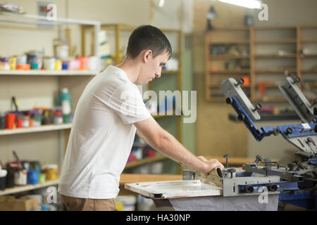 Young man working with squeegee on factory Stock Photo