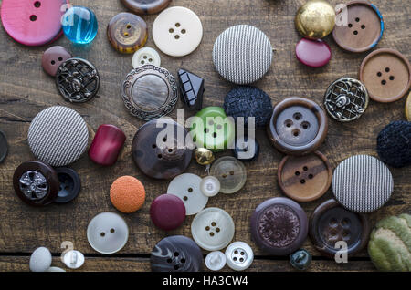 Lot of vintage buttons on old wooden table, from above Stock Photo