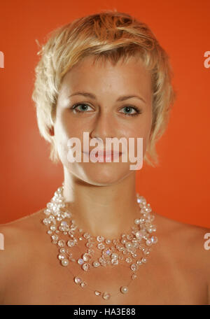 Portrait of a young blond woman wearing jewelry with a short hair cut Stock Photo