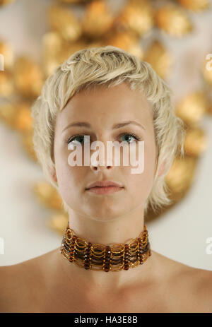 Portrait of a young blond woman wearing jewelry with a short hair cut Stock Photo