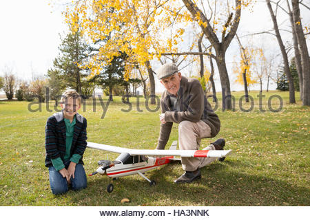 Portrait grandfather and grandson with model airplane in autumn park