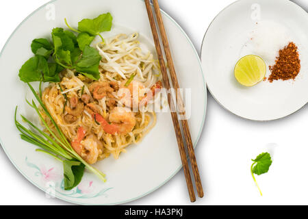 Thai style stir fried rice noodles with shrimps and vegetables on white background Stock Photo