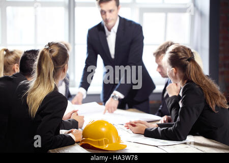 Business people group on meeting with construction engineer architect looking building blueprint Stock Photo