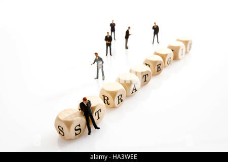 Strategie, German for strategy, written with wooden letters and miniature manager figures Stock Photo