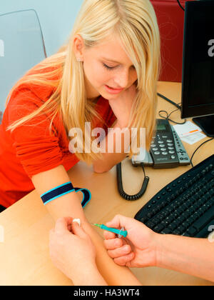 Blood sample being taken from a young woman Stock Photo