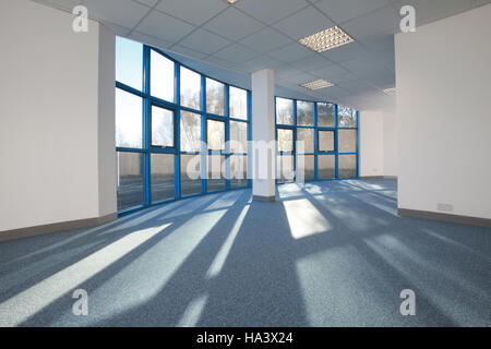 bright sunlit empty office space with sunlight streaming through windows Stock Photo