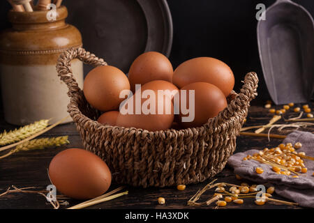 Free range eggs in a basket with corn and straw. Stock Photo