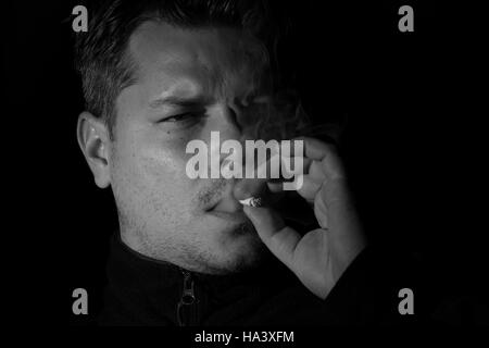 Young man smoking cigarette monochome Stock Photo