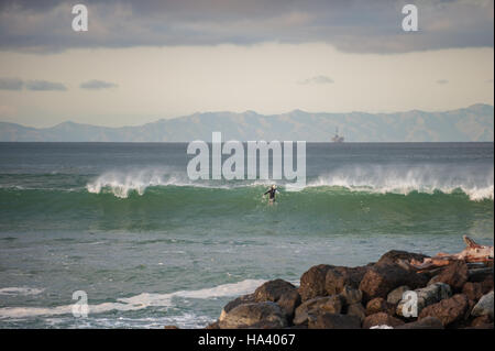 Courageous surfer making it over the top of a wave about to break. Stock Photo