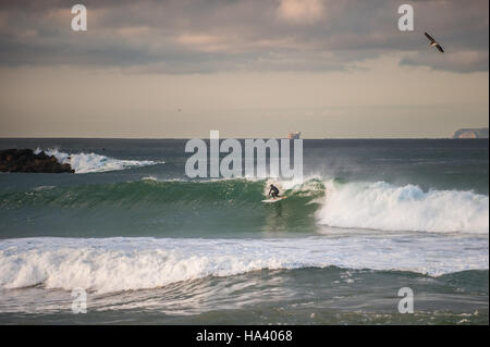 Surfer taking high line on large wave with Santa Cruz Island in background. Stock Photo