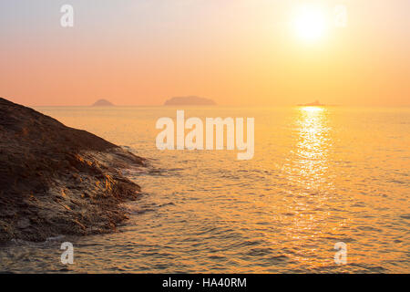 Rocky sea shore against the setting sun.