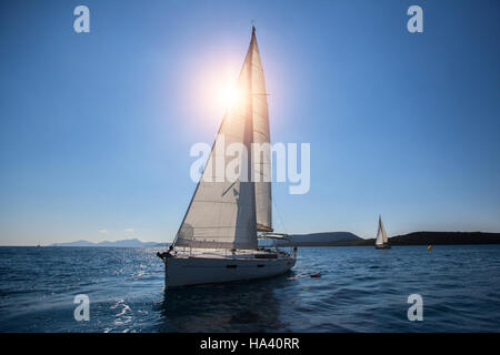 Luxury sailing ship yachts boat with white sails in the Sea. Stock Photo