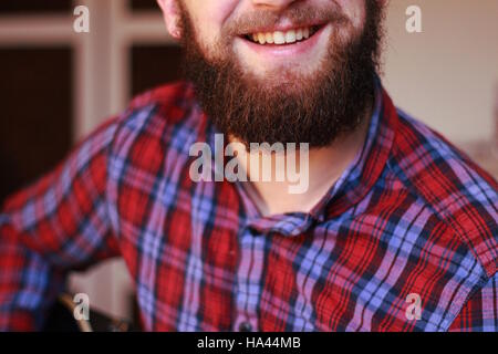 Smiling man with beard wearing a checked shirt Stock Photo