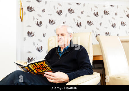 Man reading book, book reader, oap reading book hardback books thriller hobby sat reading reads to himself pensioner reading book old man reading book Stock Photo