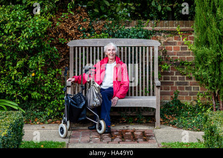 An Elderly Disabled Woman Sitting On A Bench, Sussex, UK Stock Photo