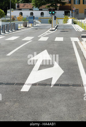 Directional white arrows symbol, in a typical entryway parking underground. Stock Photo