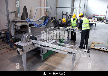 Group of industrial factory workers working with CNC machine Stock Photo