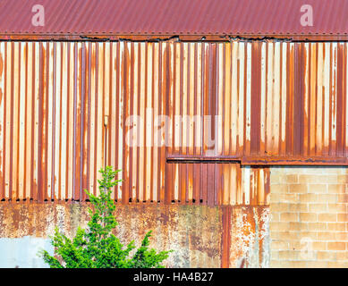 detail of a corrugated commercial building with rust and signs of exposure to the elements Stock Photo