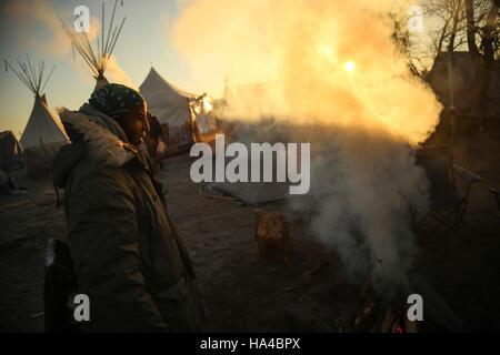 November 25, 2016 - Cannon Ball, North Dakota, U.S - DAVID OMONDI stands by a campfire during sunrise at the Oceti Sakowin Camp at the Standing Rock Indian Reservation in Cannon Ball, North Dakota. (Credit Image: © Joel Angel Juâ€¡Rez via ZUMA Wire) Stock Photo