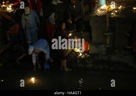 Kathmandu, Nepal. 27th Nov, 2016. A Nepalese Hindu worshipper carrying oil lamps offering prayers in memory of departed beloved ones during Bala Chaturdashi festival on the banks of the Bagmati River at Pashupathinath Temple in Kathmandu, Nepal, on Sunday, November 27, 2016. Bala Chaturdashi festival is observed in remembrance of late beloved ones, a belief that by performing rituals the departed souls can secure a better place in heaven. © Skanda Gautam/ZUMA Wire/Alamy Live News Stock Photo