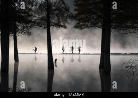 Yixian, China's Anhui Province. 28th Nov, 2016. Photographers take photos of fog-enveloped Qishu Lake in Yixian County of Huangshan City, east China's Anhui Province, Nov. 28, 2016. Credit:  Chen Yehua/Xinhua/Alamy Live News Stock Photo